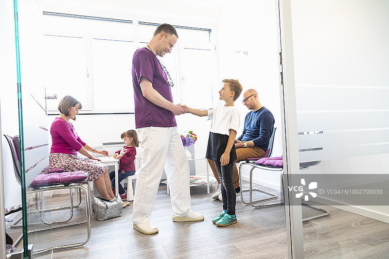 牙医欢迎一位年轻男孩图片素材