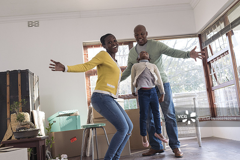 年轻非洲家庭兴奋跳跃搬新家图片素材