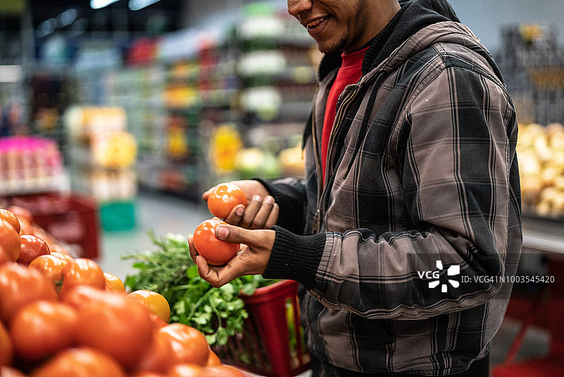 顾客在超市挑选番茄图片素材