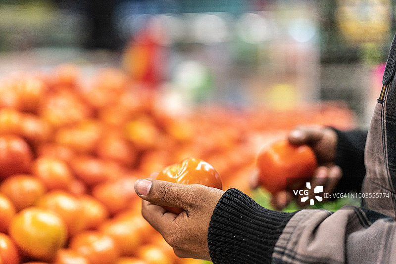 顾客在超市挑选番茄图片素材