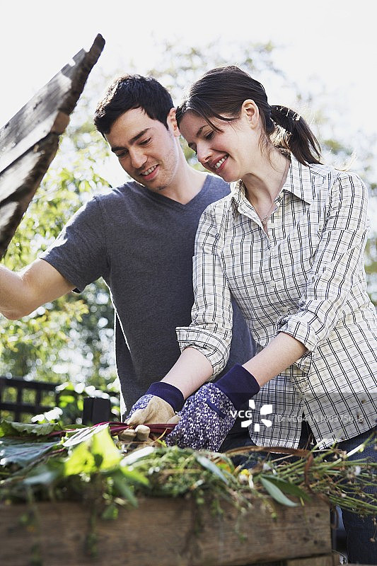 年轻情侣使用堆肥箱图片素材