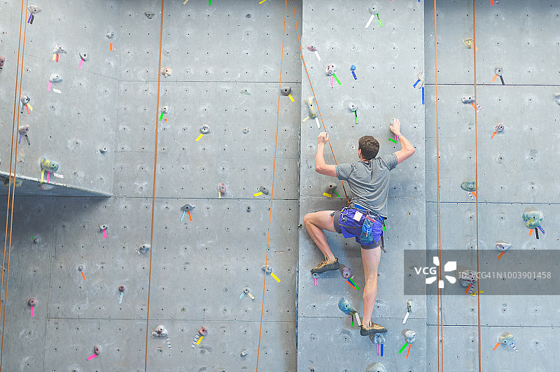 大学生攀爬室内攀岩墙图片素材