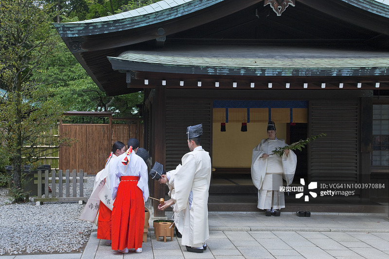 日本东京明治神宫的神道教祭司和神社少女的净化仪式图片素材
