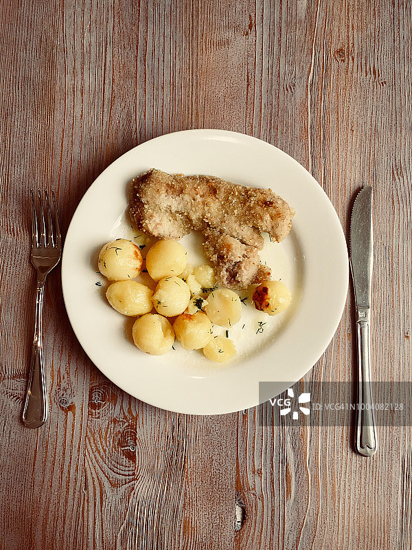 男人吃炸猪排和迷你土豆图片素材