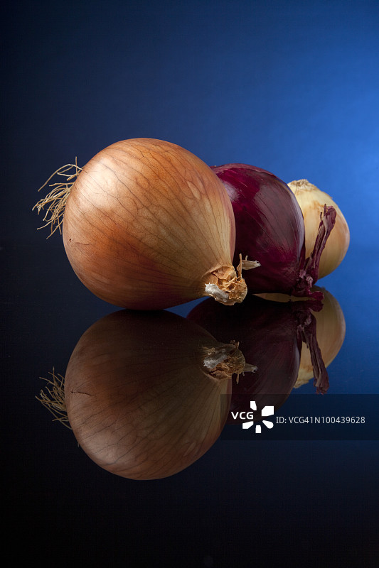 黑色玻璃上的黄色和红色洋葱图片素材