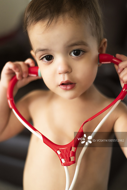 生病并玩玩具听诊器的幼儿图片素材