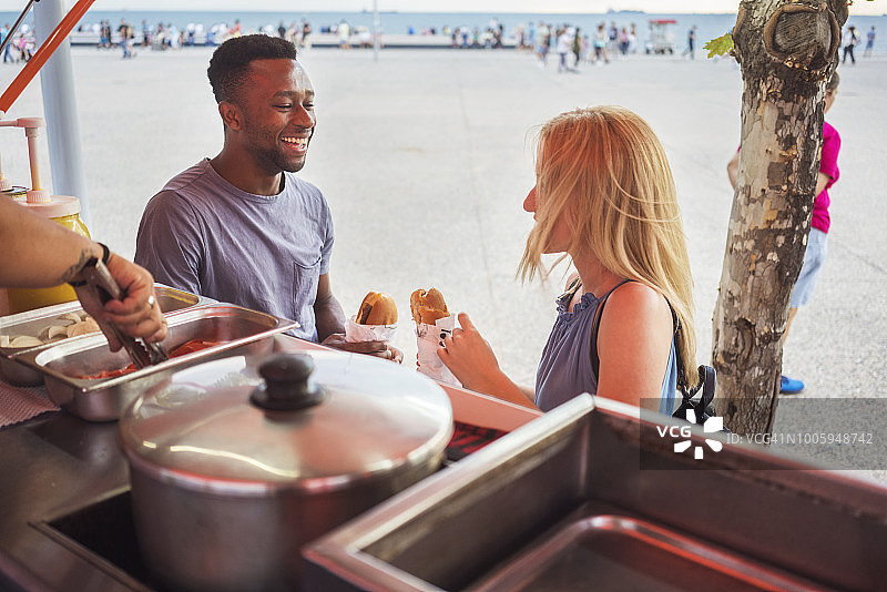 年轻情侣在餐车前吃东西图片素材