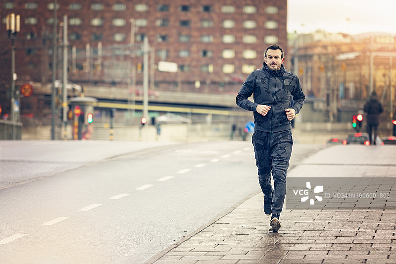 在城市跑步和慢跑的英俊跑步者图片素材
