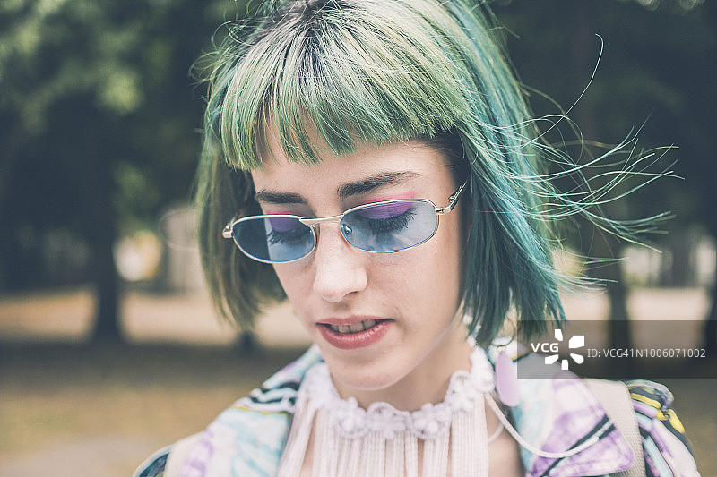 开心微笑的时尚绿发女孩低头图片素材