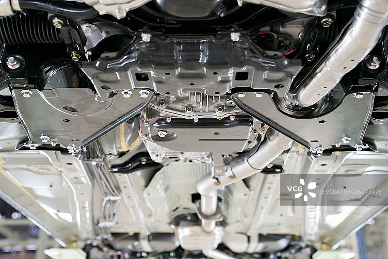 商业底盘在机舱下，不同气动、电气设备和各种零件细节的特写镜头。汽车修理厂。汽车在升降机上进行检查维护修理。图片素材