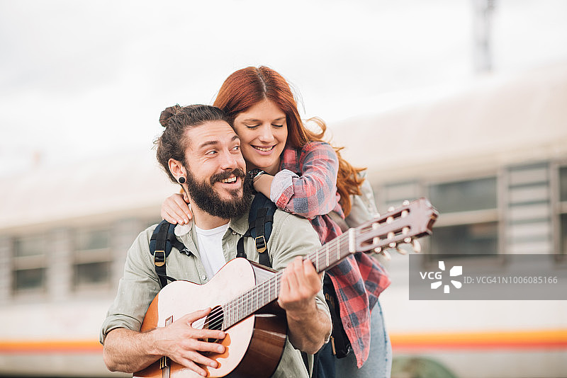 红发女人拥抱抱着原声吉他的音乐家图片素材