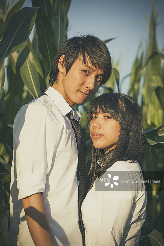 穿着校服的亚洲情侣在玉米地里图片素材