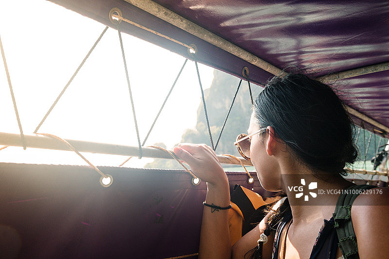 乘坐传统长尾船抵达泰国甲米的西班牙裔美国妇女图片素材