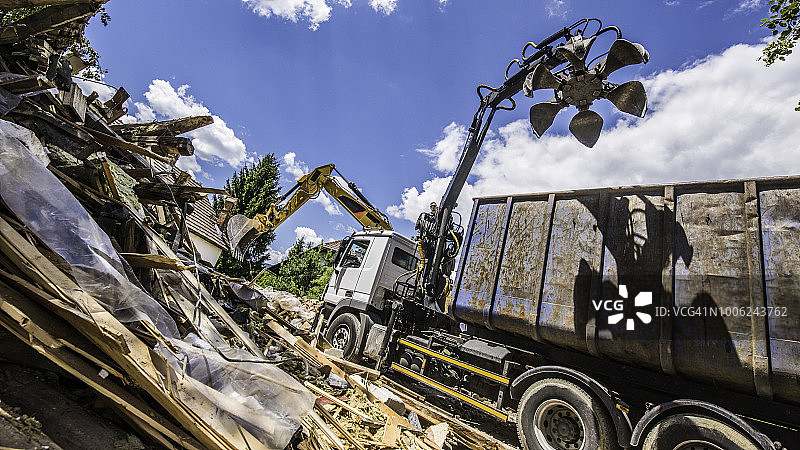 带有机械臂的自卸卡车在废墟旁图片素材