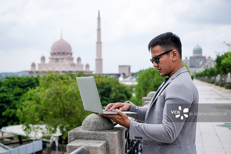 携带笔记本电脑在户外旅行的商人图片素材
