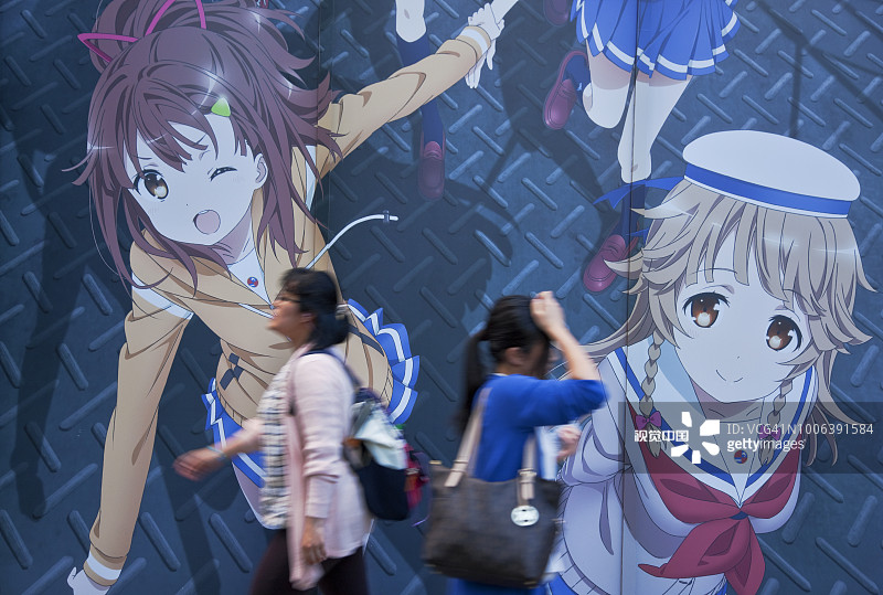 东京秋叶原电器街中央大街上的年轻女性和动漫壁画图片素材