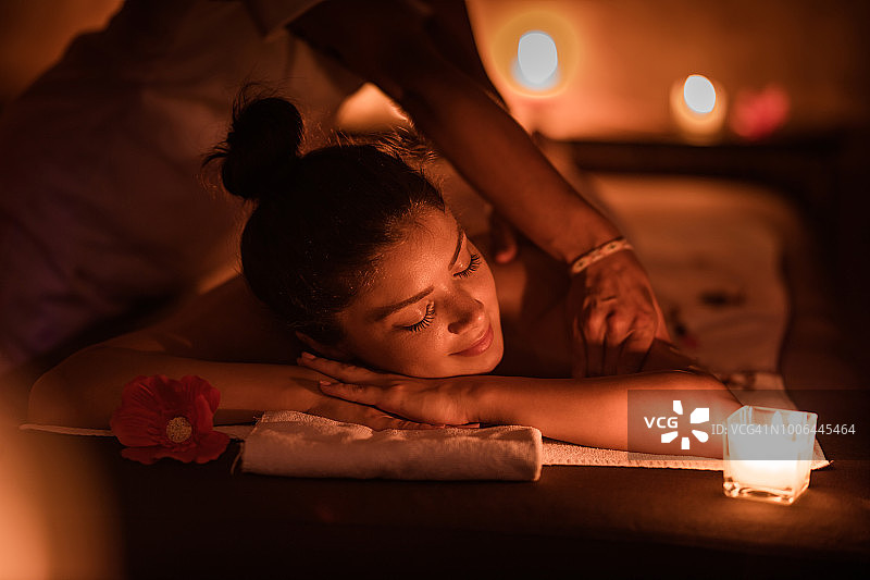 年轻女人在水疗中心享受放松按摩图片素材