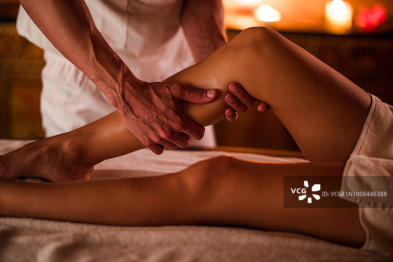 理疗师在水疗中心为女子按摩腿部图片素材