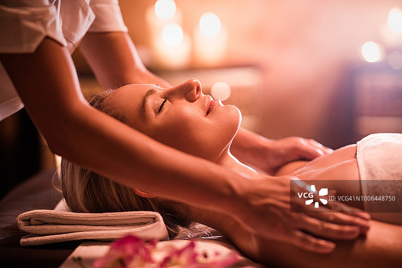 微笑的女人在美容水疗中心享受放松按摩图片素材