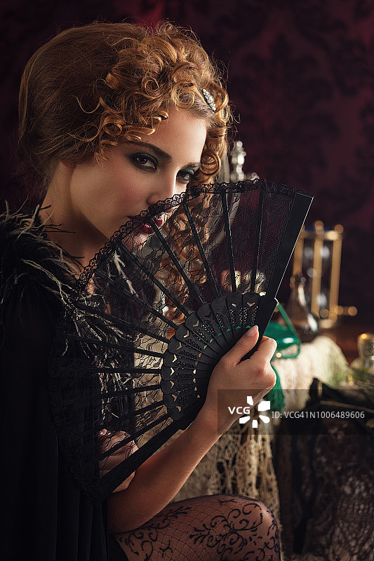 手持蕾丝扇的复古年轻女子图片素材