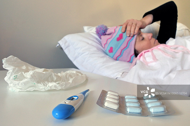 在床上感冒并头痛的生病妇女图片素材