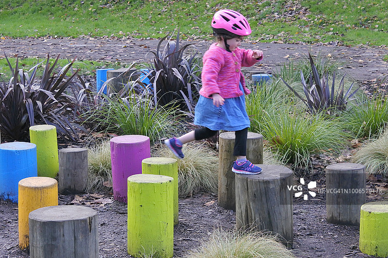 女孩通过木杆障碍赛跑图片素材