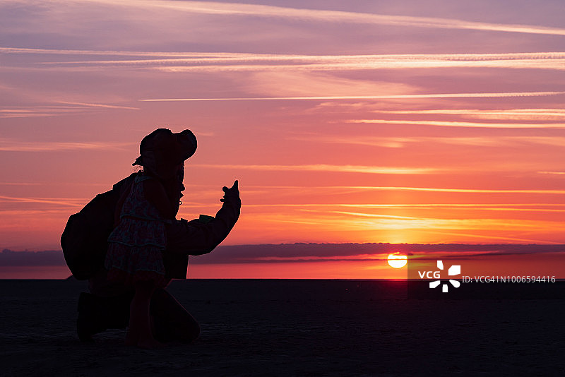 小女孩在法国圣米歇尔山海湾和叔叔一起观看日落图片素材