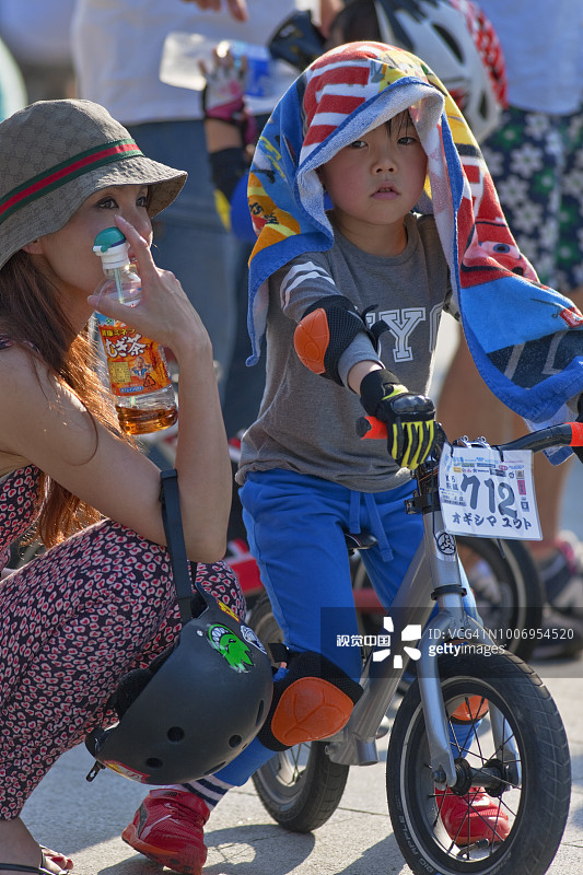 在东京台东区上野公园举行的儿童滑步车比赛中提供支持的母亲图片素材