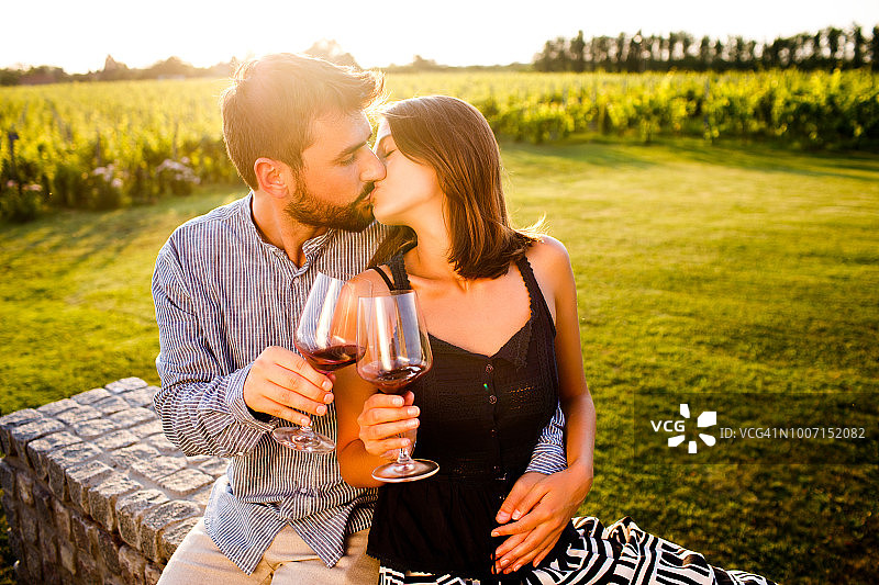 接吻并品尝葡萄酒的浪漫情侣图片素材