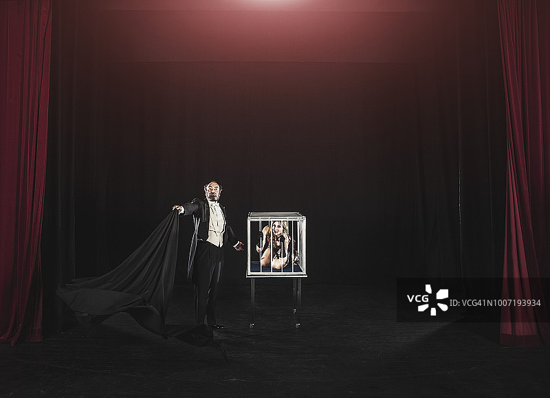 舞台上的魔术表演：笼中助手图片素材