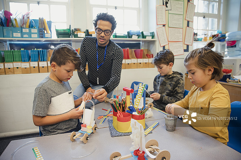 在小学课堂上与老师一起搭建积木的男学生们图片素材