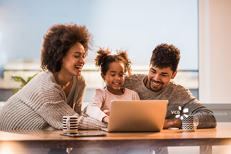 年轻快乐的黑人家庭在家用电脑上网图片素材