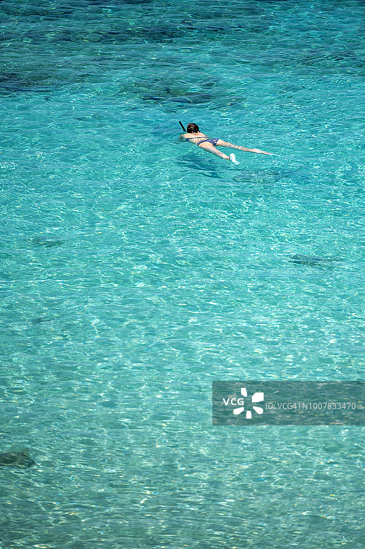 年轻女人在马来西亚停泊岛清澈的海水中浮潜图片素材