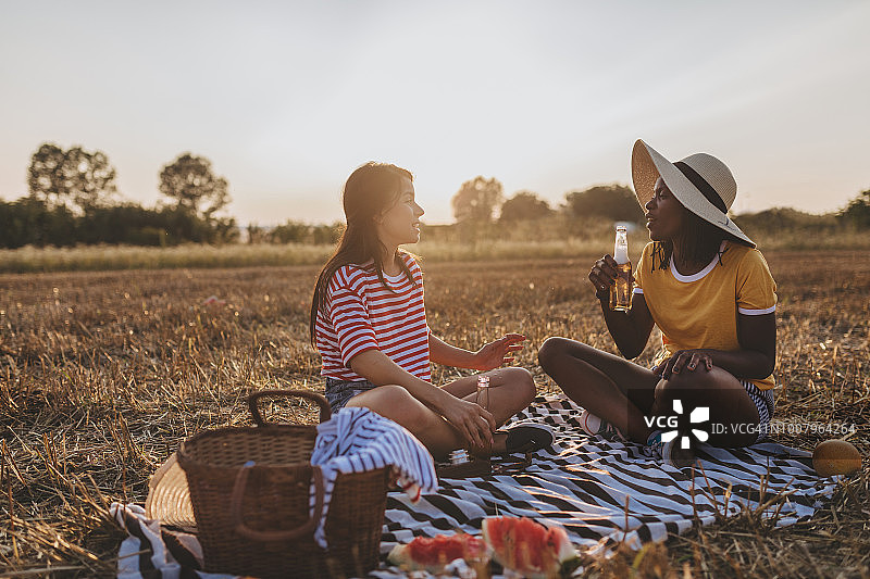 在野餐时看手机的漂亮朋友们图片素材