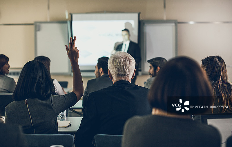 在研讨会上举手的商务女人图片素材