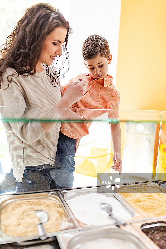 母亲抱着儿子在甜品店里图片素材