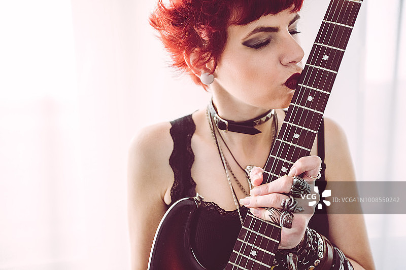 亲吻吉他的金属风格女人图片素材