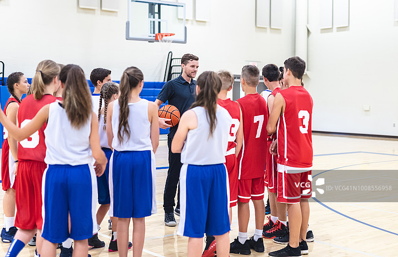 教练在球场上与男女混合高中篮球队交谈图片素材