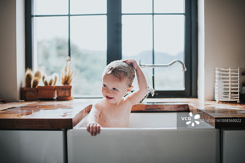 可爱的幼儿在水槽里洗澡图片素材