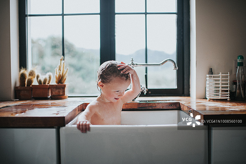 可爱的幼儿在水槽里洗澡图片素材