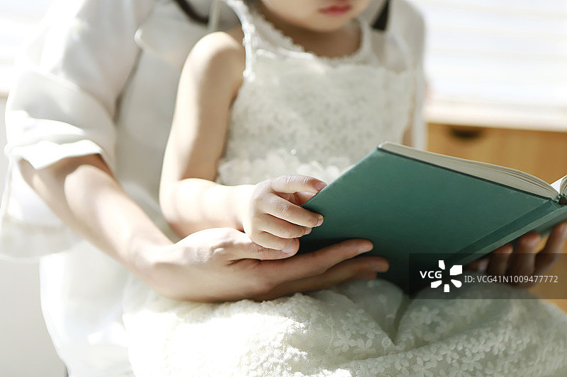 女婴和母亲一起读书图片素材