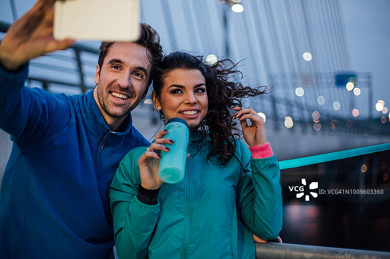 一对健康的夫妇微笑着用手机自拍图片素材