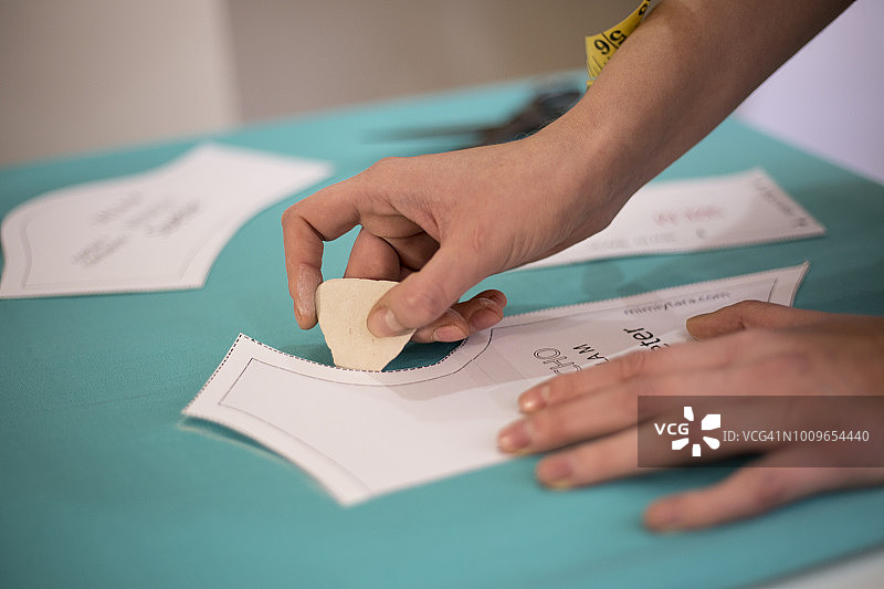 女裁缝用剪刀裁剪服装图样，款式和设计开发，服装缝纫和修理服务，女裁缝工作场景图片素材