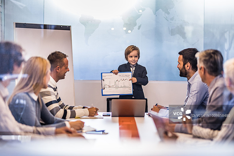 可爱的商务男孩在办公室会议上向他的团队展示业务报告图片素材