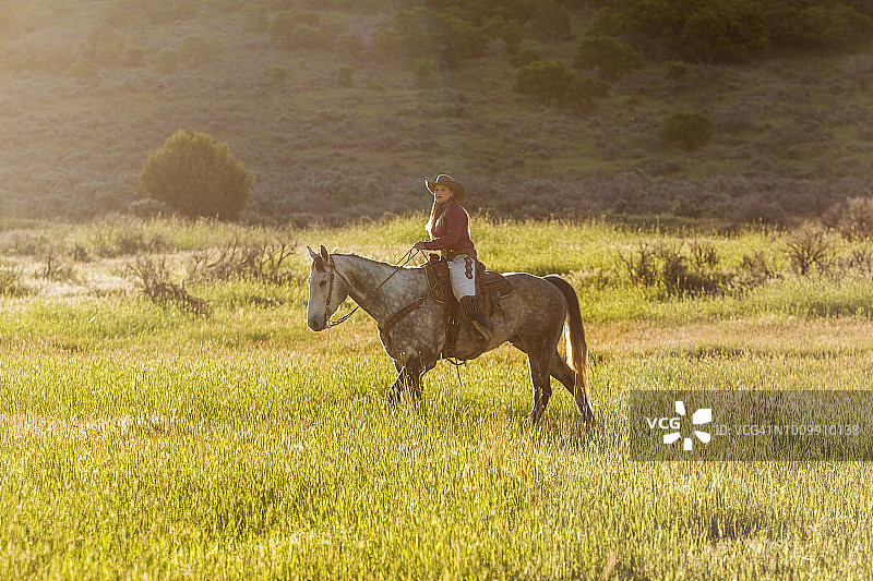 在盐湖城圣奎因山谷骑马的金发女牛仔图片素材
