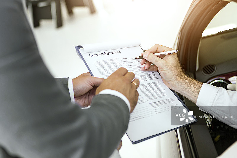 汽车销售员与客户签订合同图片素材