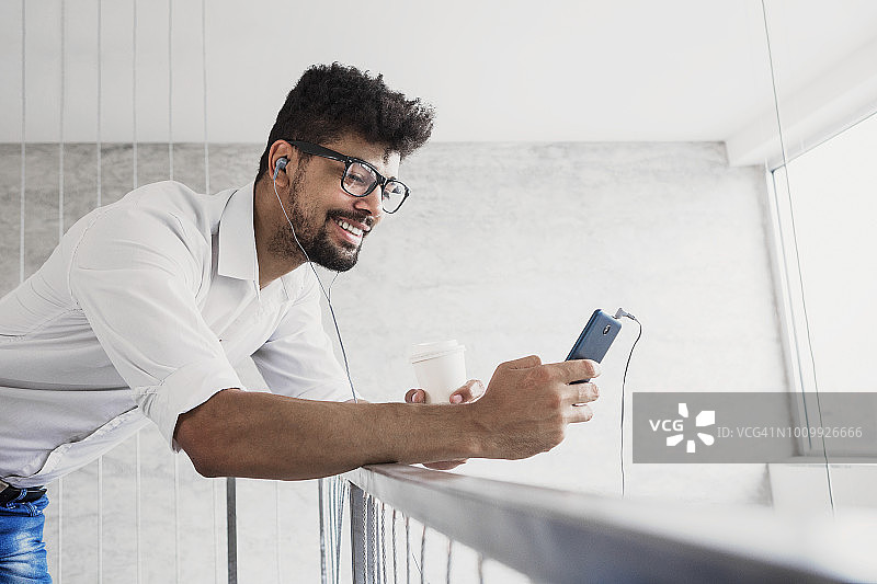 非裔美国男人用智能手机听喜欢的音乐图片素材