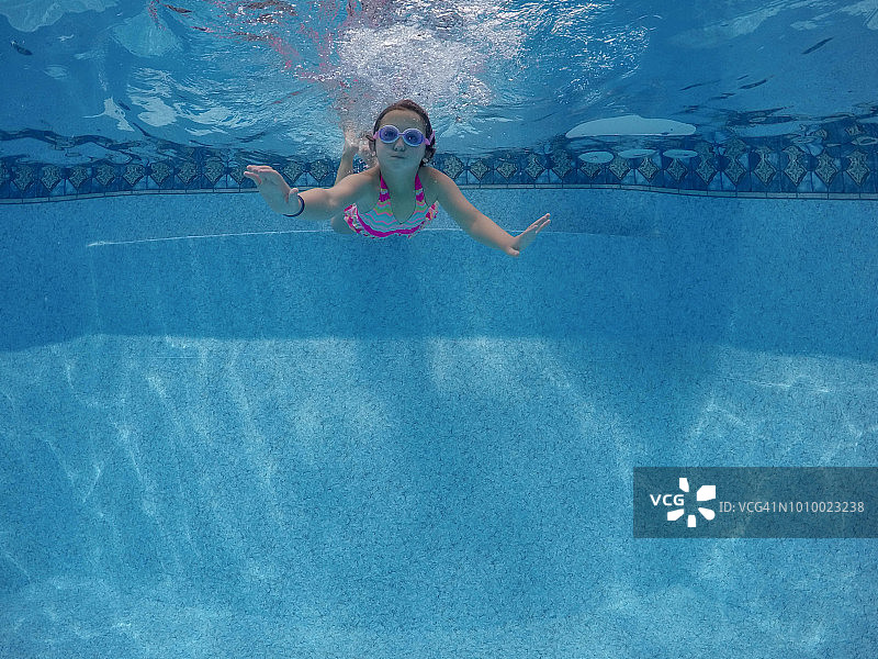 年轻女孩在私人泳池游泳的水下照片图片素材