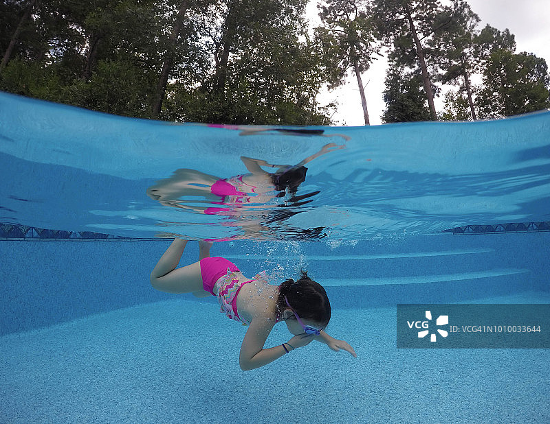 年轻女孩在私人泳池游泳的水下照片图片素材