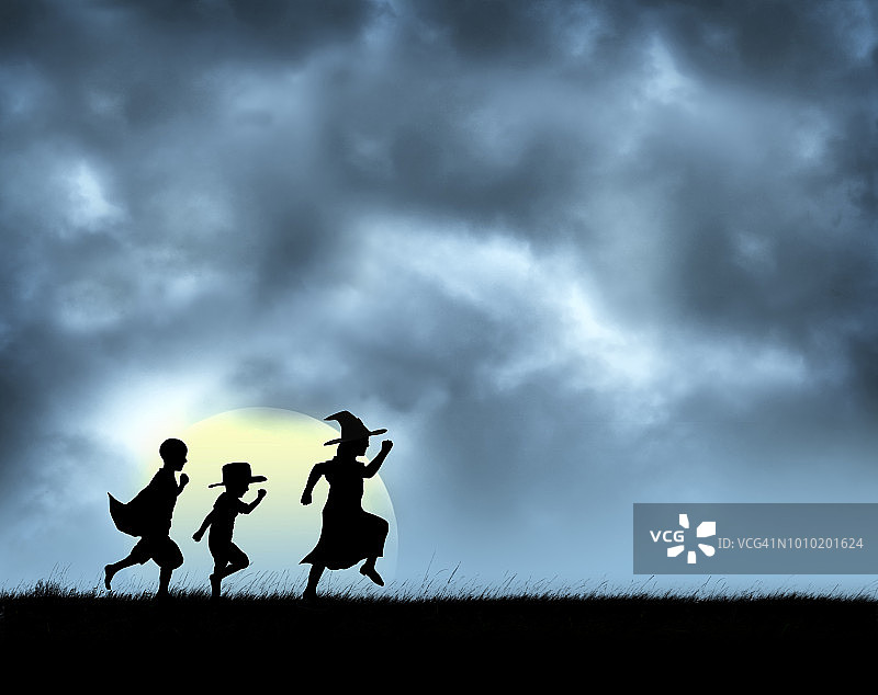 万圣节装扮的三个孩子，以月亮为背景图片素材